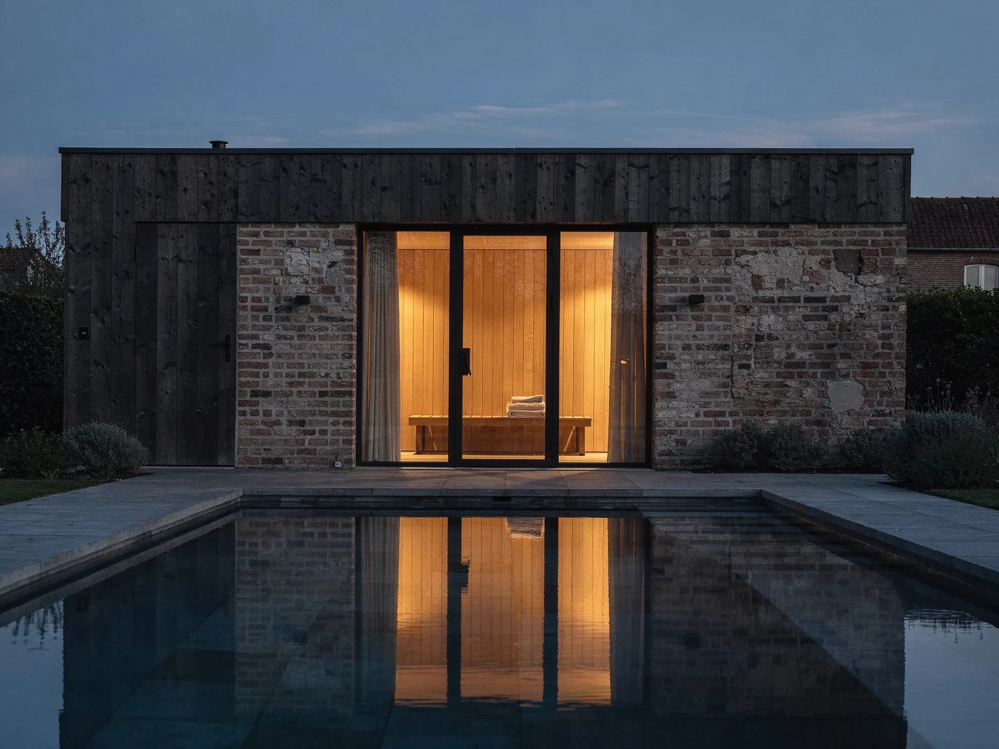 Conceptbeeld van een avondlijke Belgische tuin met zwembad en poolhouse met zichtbare sauna